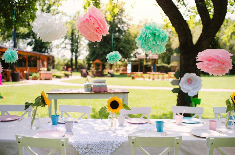 Outdoor picnic setup with colorful blankets, baskets, and kids playing