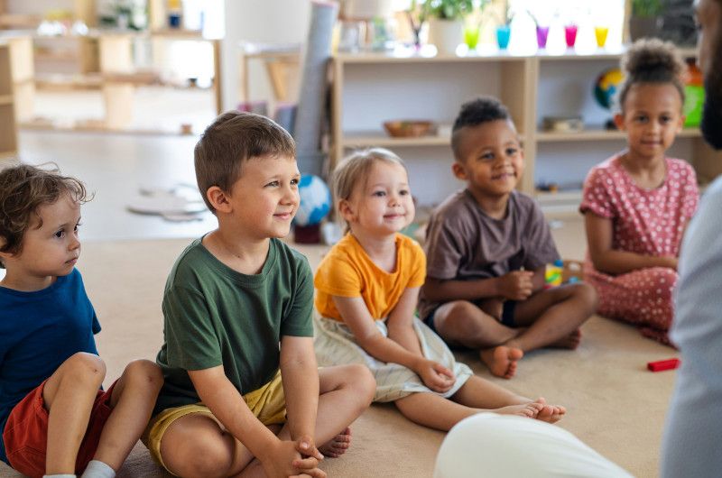 Children sitting in a circle listening to a story