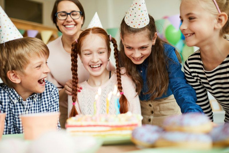 A happy mother and happy children at the birthday table